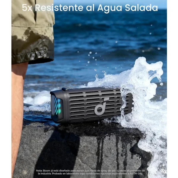 Parlante Soundcore Boom 3i Negro resistente al agua salada recibiendo salpicadura de ola en la playa